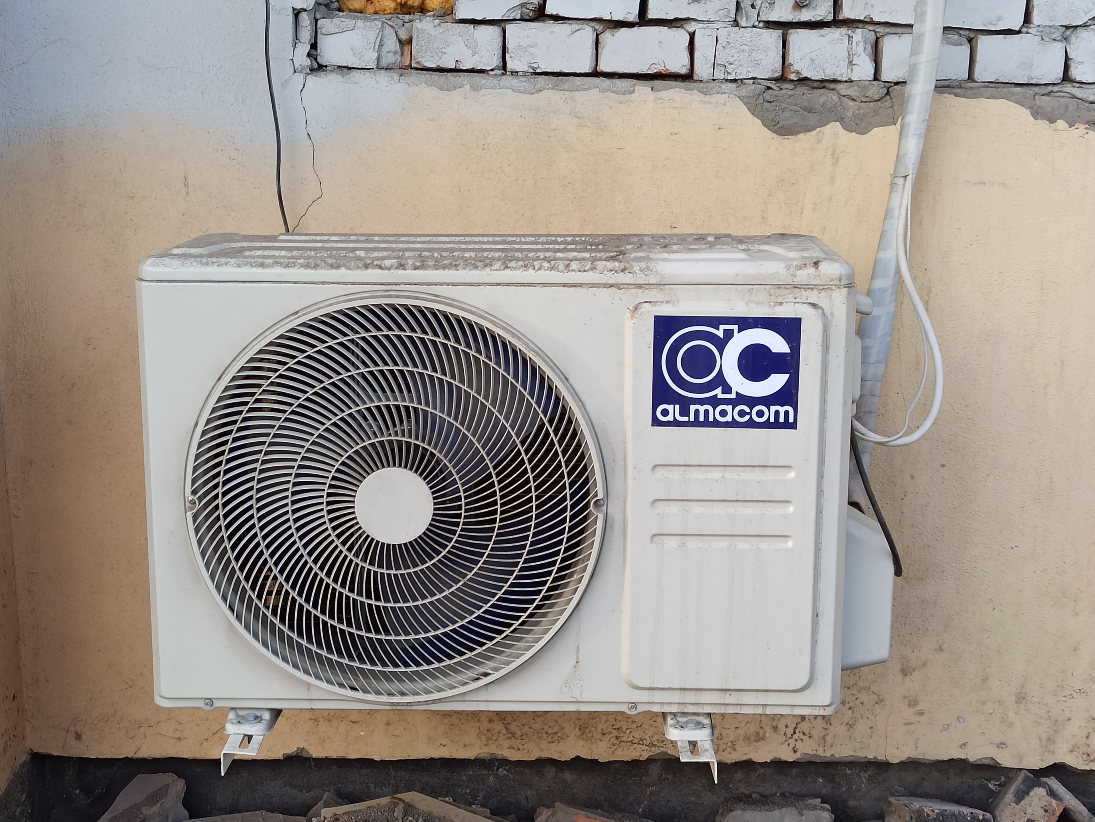 Worn outdoor AC condenser unit showing signs of age and wear